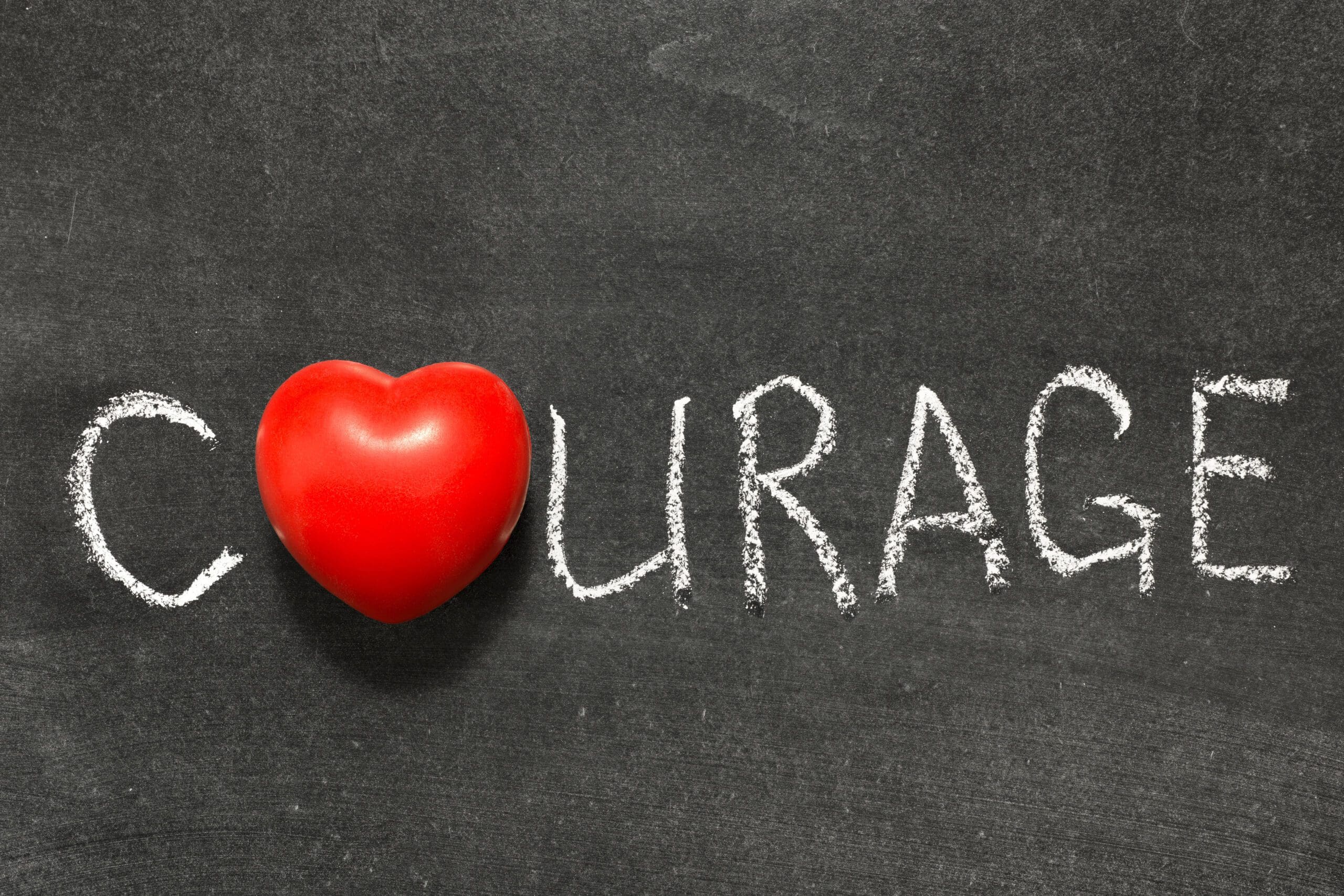 courage word handwritten on chalkboard with heart symbol instead of O- Latin Business Today