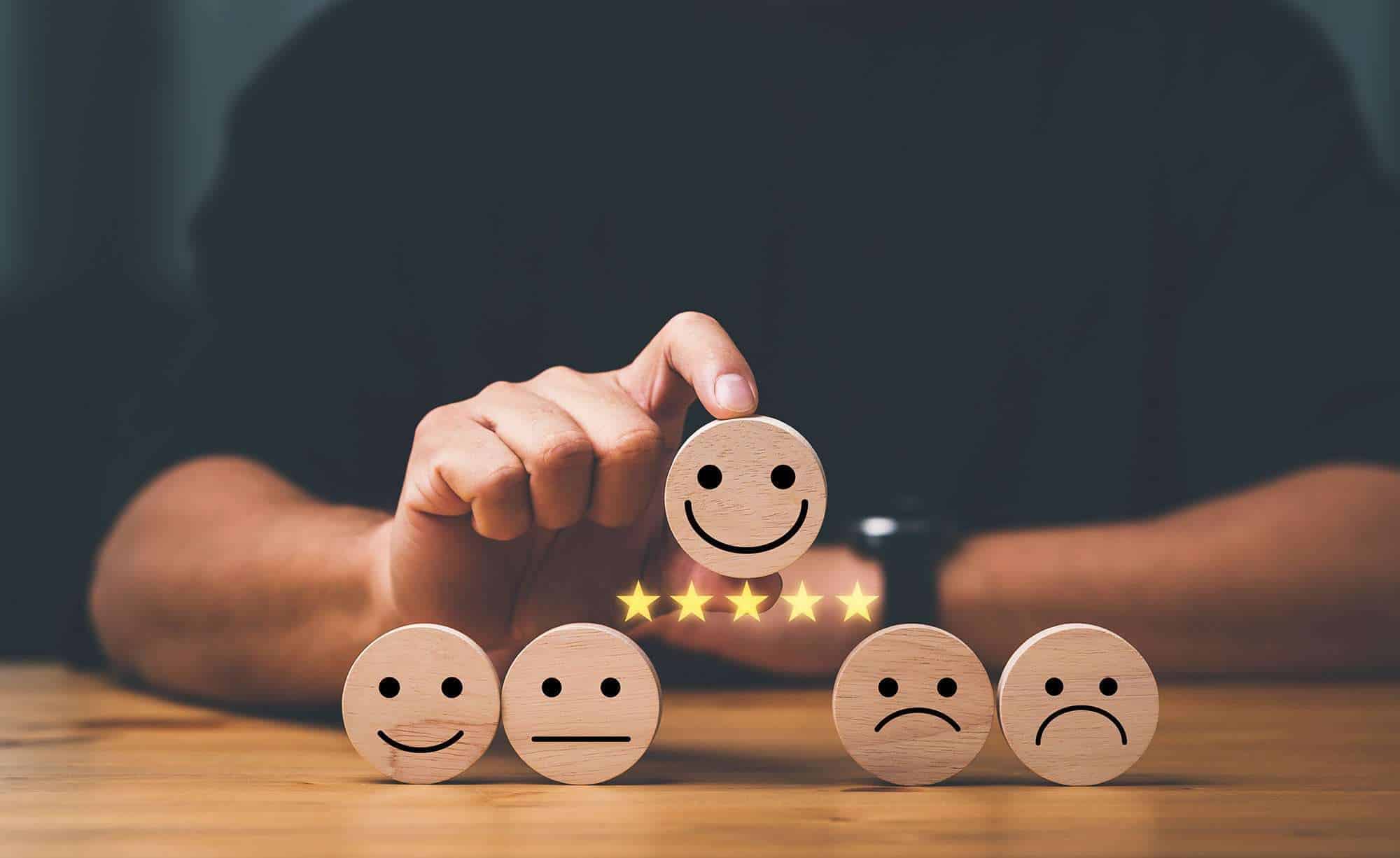 customer services best excellent business rating experience. Satisfaction survey concept. Hand of a businessman chooses a smile face on wood block cube. 5 Star Satisfaction.