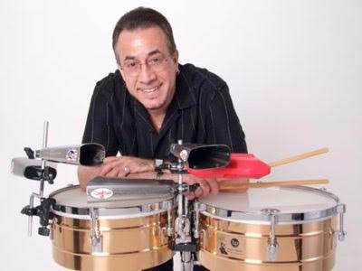 Bobby Sanabria sitting comfortably where he is happy-- at his drum kit