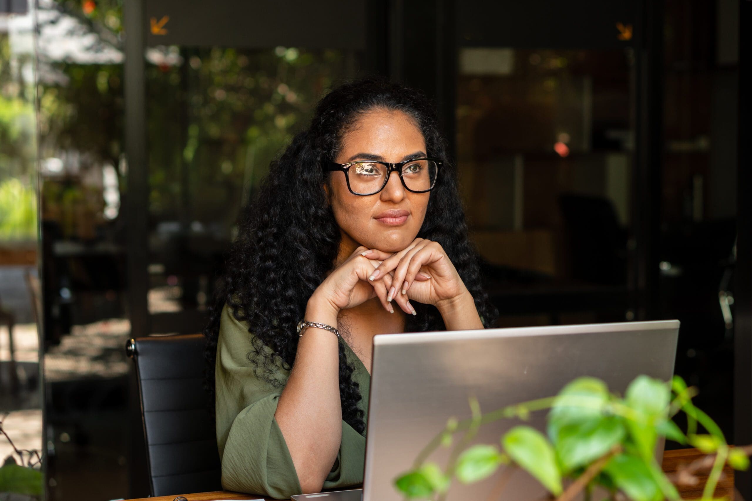 Hispanic business woman thinking about the future and planning in the office. .